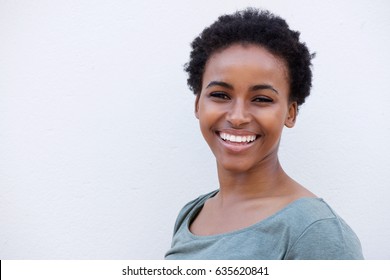 Close Up Portrait Of Beautiful Young Black Woman Smiling Against White Background 