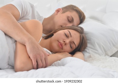 Close up portrait of beautiful young couple sleeping on soft bed in morning