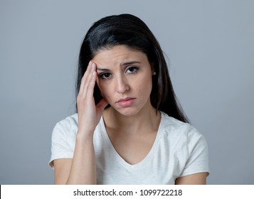 Close up portrait of a beautiful young latin hispanic woman with a depressed face. looking miserable, melancholy and sad. Human facial expressions and emotions concept. Grey background