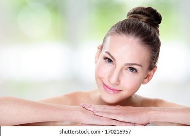 Close Up Portrait Of Beautiful Young Woman Face While Lying. Isolated On Green Background. Skin Care Or Spa Concept