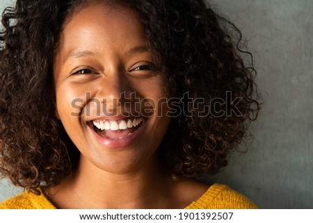 Close up portrait beautiful young woman with curly hair laughing