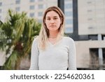 Close up portrait of blonde caucasian young woman looking serious at camera. Pretty teenage girl staring front with sad attitude. High quality 4k footage