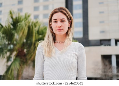 Close up portrait of blonde caucasian young woman looking serious at camera. Pretty teenage girl staring front with sad attitude. High quality 4k footage