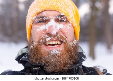 A Close Portrait Of A Brutal Man With A Beard, All Face In The Snow, In A Snowy Forest