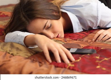 Close Up Portrait Of A Business Woman Tired And Sleeping In An Hotel Bed With A Mobile Phone