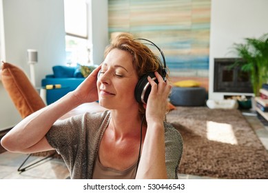 Close Up Portrait Of Carefree Older Woman Listening To Music At Home