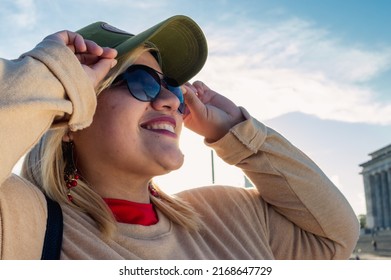 close up portrait caucasian argentinian young latin tourist woman, wearing sunglasses outdoors in the city of buenos aires, smiling looking to the side, with copy space.