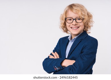 Close up portrait of a caucasian blonde preteen elementary primary middle school pupil boy kid child with arms crossed wearing uniform eyeglasses on white background, copy space. Education concept - Powered by Shutterstock