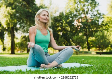 Close up portrait of caucasian mature woman in sporty outfit relaxing meditating feeling zen-like on fitness mat in public park outdoors. Healthy active lifestyle - Shutterstock ID 2168252723