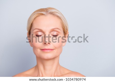 Close up portrait of charming, pretty, attractive woman with perfect skin after cream, balm, mask, lotion, isolated on grey background, having eyes closed, natural maqullage, make up