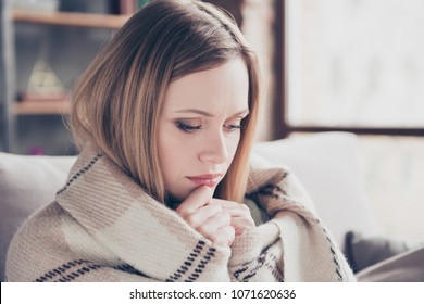 Close up portrait of charming, pretty, unhappy woman covered by plaid, holding two hands near face, looking down, worry about something having problems in relationship