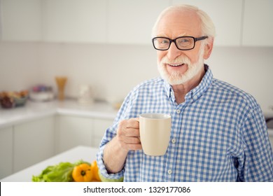 Close up portrait cheer grey haired he his him grandpa hot beverage hand arm look window ponder pensive imagination flight wear specs casual checkered plaid shirt jeans denim outfit light room - Powered by Shutterstock