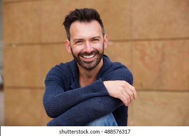 Close Up Portrait Of Cheerful Middle Aged Man Sitting Outdoors And Smiling