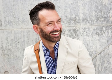 Close Up Portrait Of Cheerful Middle Aged Man With Beard Standing Against Wall And Smiling