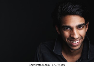 Close Up Portrait Of A Cheerful Young Man Laughing On Black Background