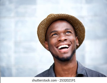 Close up portrait of a cheerful young man laughing and looking up