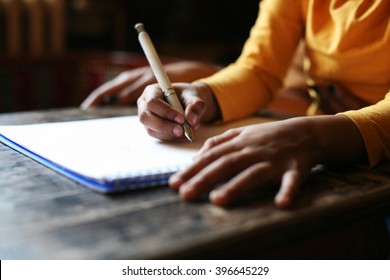 Close up portrait of child's hands writing.   