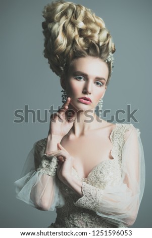 A close up portrait of a cold beautiful lady posing in the studio over the grey background. Beauty,cosmetics, hairstyle.