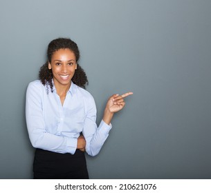 Close up portrait of a confident business woman pointing finger on gray background - Powered by Shutterstock