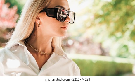 Close Up Portrait Of Confident Business Woman Walking In The Public Park, Elegant Female Entrepreneur Wearing Sunglasses And Golden Jewelry Looking Away