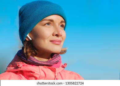 Close Up Portrait Of A Confident Woman At The Seaside Listening To Music In Ear Pods