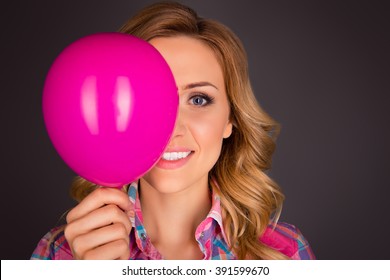 Close up portrait of creative woman holding balloon near face