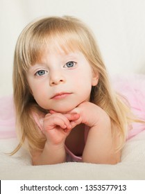 Close up portrait of Cute Blonde Toddler, 2 Years Old Girl, with Big Blue Eyes, in Pink fluffy Dress, Happy Child, The Most Beautiful Girl in the world