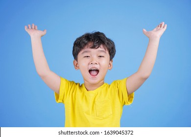 Close up portrait of cute boy pointing with finger gesture, isolated on blue background