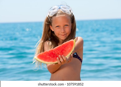 Close up portrait of cute girl eating watermelon at seaside.