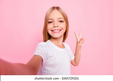 Close up portrait of cute lovely sweet funky adorable beautiful charming with toothy with blonde hairstyle beaming smile girl making v-sign gesture white tshirt isolated on pink background - Shutterstock ID 1045729201