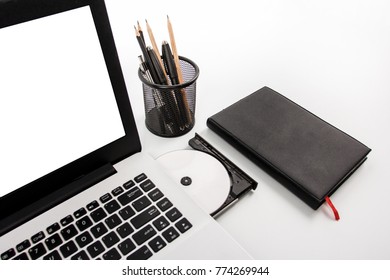 Close Up Portrait Of Disc On Laptop With Notebook And Stationary Isolated On White Background