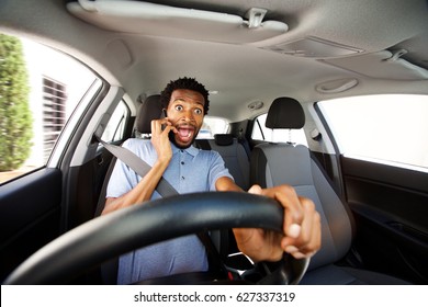 Close up portrait of distracted man driving in car talking on smart phone