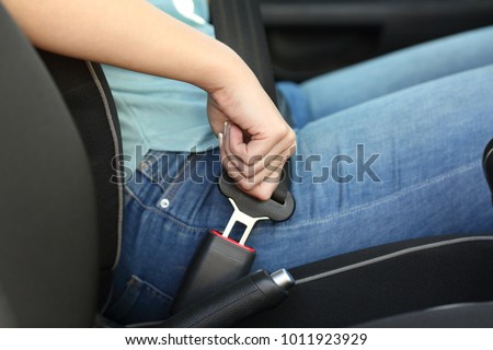 Close up portrait of a driver hand fastening seatbelt in a car 商業照片 © 