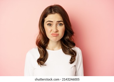 Close Up Portrait, Face Of Woman Cringe, Grimacing Disappointed, Looking Awkward Or Upset, Standing Over Pink Background