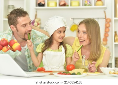 Close Up Portrait Of Family Cooking Together At Kitchen Table