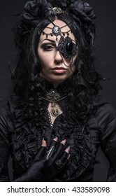 Close up portrait of fatal woman in vintage black dress and decor on face posing on dark background