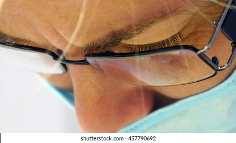 Close up portrait of female doctor in glasses with protective work wear. Female face in medical mask. Cosmetologist or therapist is working