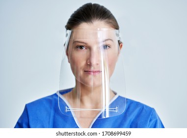 Close up portrait of female medical doctor or nurse wearing face shield
