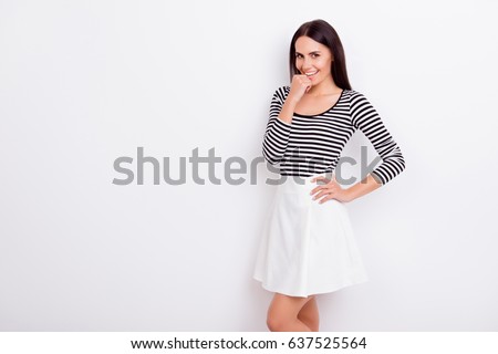 Close up portrait of flirty attractive lady. She is wearing casual outfit and stands on pure white background