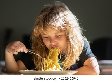 Close Up Portrait Of Funny Kid Eating Noodles Pasta Spaghetti. Little Boy Having Breakfast In The Kitchen.