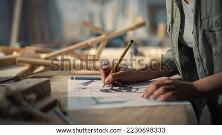 Close Up Portrait of a Furniture Designer Writing Down Dimensions and Assembling Legs of a Wooden Chair. Stylish Black Female Carpenter Working in Studio in Loft Space with Tools on the Walls. 商業照片 © 