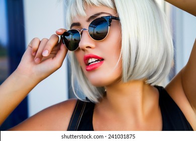 Close Up Portrait Of Gorgeous Woman In Stylish Sunglasses  Perfect Skin , White Teeth And Red Full Lips In White Short Wig.