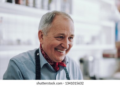 Portrait en gros plan de vieil homme aux cheveux gris regardant au loin et souriant. Il portait le cou rouge : photo de stock