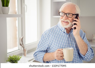 Close up portrait grey haired he his him grandpa hot beverage hand arm tell children health condition telephone smart phone user wear specs casual checkered plaid shirt jeans denim outfit room kitchen - Powered by Shutterstock