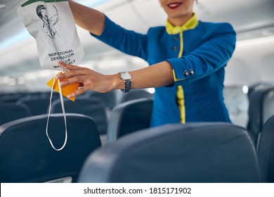 Close Up Portrait Of Hands Of Flight Attendant On A Commercial Passenger Jet Reaching For An Oxygen Mask