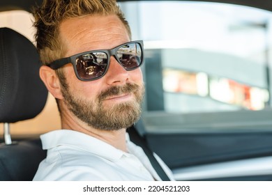 Close Up Portrait Of Handsome Young Man Wearing Sunglasses In The Car.