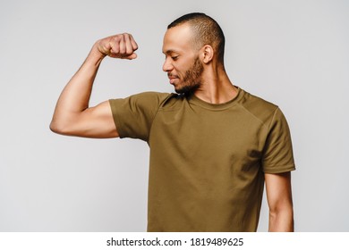 Close Up Portrait Of A Happy African American Man Wearing T-shirt Flexing Bicep Arm Muscle