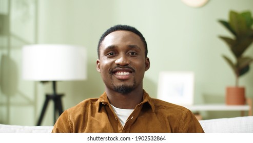 Close Up Portrait Of Happy African American Young Man At Home, Raising Head Looking At Camera Smiling On Home Decor Background.