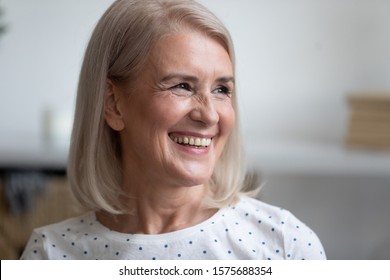 Close Up Portrait Happy Aged Woman With Candid Wide White Smile Looks Away, Pretty Middle-aged Female Posing Indoors Feels Satisfied Spend Time At Home, Natural Looking Beauty, Healthy Retiree Concept