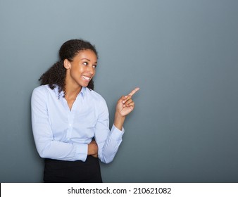 Close Up Portrait Of A Happy Business Woman Pointing Finger On Gray Background